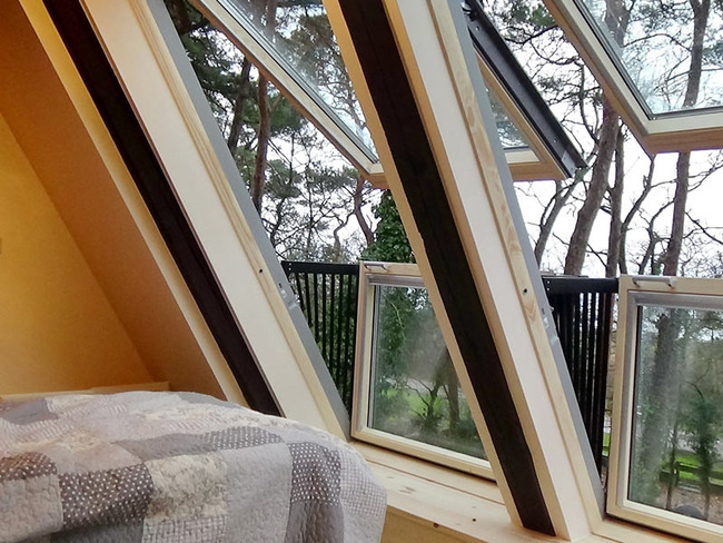 Schlafzimmer mit Panoramafenster im Dachgeschoß