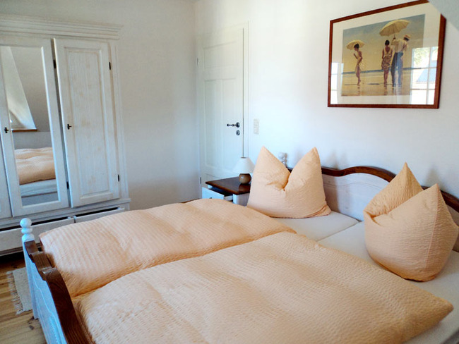 Obere Ferienwohnung: Schlafzimmer mit Doppelbett, Nachtschrank, Tischlampe, Kleiderschrank Spiegel