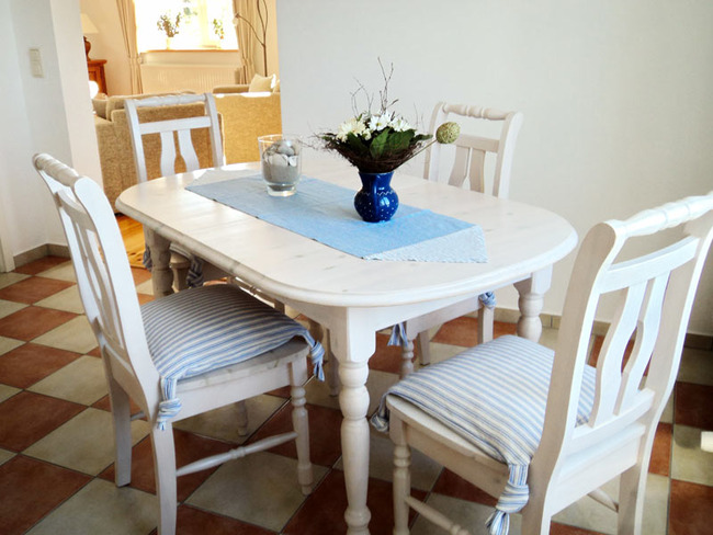 Obere Ferienwohnung - Küche mit weißem Esstisch und 4 Stühlen und Durchgang zum Wohnzimmer