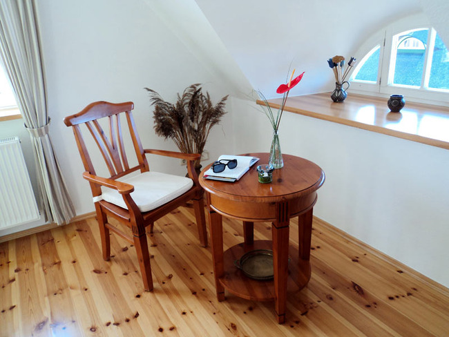 Obere Ferienwohnung - Leseecke unterm Gaubenfenster mit kleinem Tisch und Stuhl