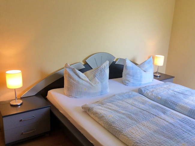 Ferienwohnung 3 - helles Schlafzimmer mit Doppelbett, Nachtschränken und Nachttischlampen