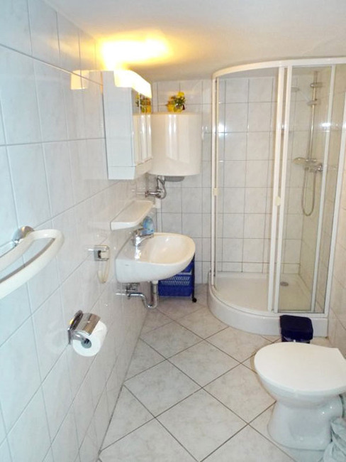 Ferienhaus 2 - Badezimmer mit Runddusche, Waschbecken und WC