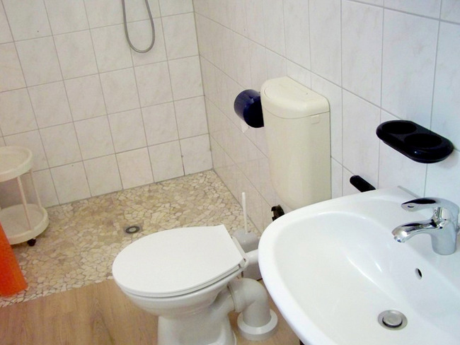 Ferienhaus 7 - Badezimmer mit befahrbarer Dusche, Waschbecken und WC