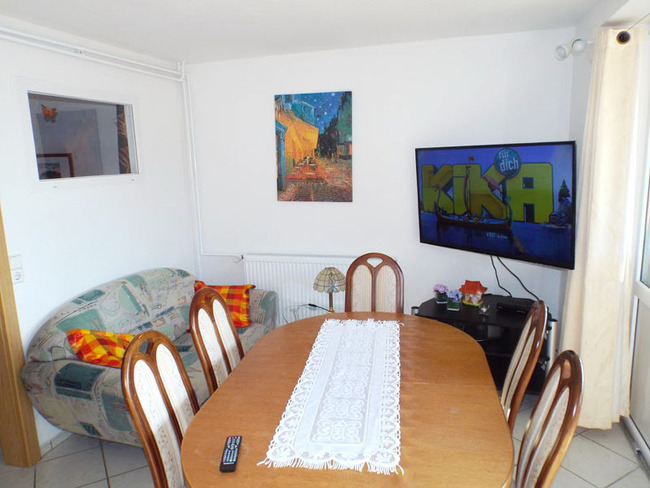 Ferienwohnung für 7 Personen - Wohnzimmer mit Esstisch, Couch und TV