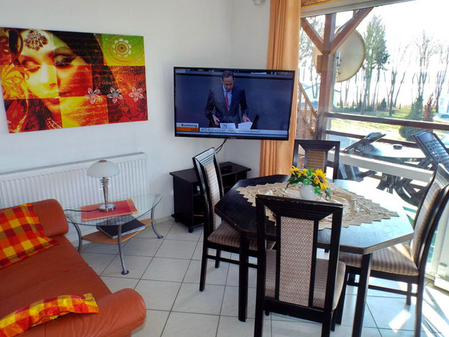 Ferienwohnung für 6 Personen - Wohnzimmer mit Couch, Esstisch, TV und Seeblick
