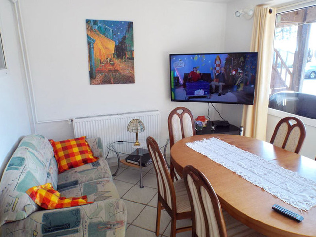 Ferienwohnung für 5 Personen - Wohnzimmer mit Couch, Esstisch und TV