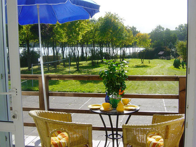 Ferienwohnung für 4 Personen - Sonnenterrasse mit Aussicht auf den Garten und See