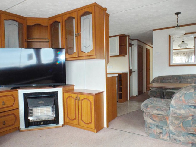 Mobilheim für 6 Personen - Wohnzimmer mit Sitzecke und TV