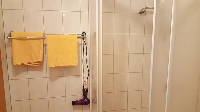 Bad mit Dusche, Handtuchhalter und Fön