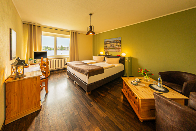 Doppelzimmer mit Bett und Schreibtisch